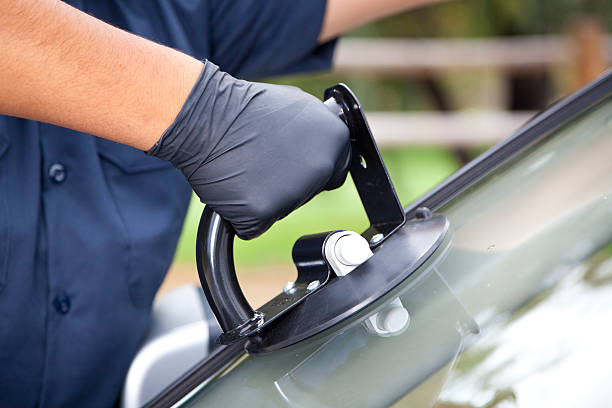 ZenGlassAuto offers you Safety First Auto glass technician carefully installing a windshield using professional safety equipment